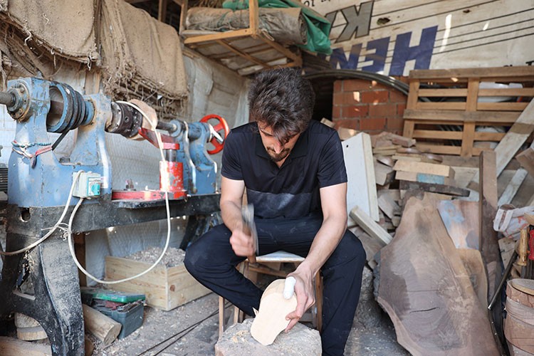 Ahşap oymacılığı meslek edinen genç mutfak gereçleri yapıyor