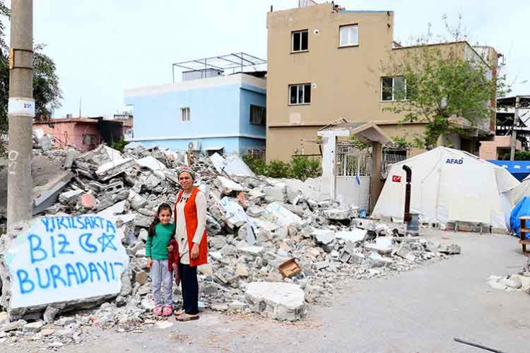 Hataylı kadın "Yıkılsak da biz buradayız" yazdıkları hasarlı evinin önünden ayrılmıyor
